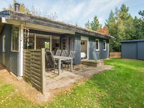 a patio with a table and chairs in a yard at 6 person holiday home in R m in Bolilmark