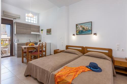 a bedroom with two beds with a blue hat on it at Galini Apartments in Hersonissos