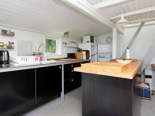 Asnæsにある4 person holiday home in Asn sのキッチン(黒いキャビネット、木製カウンタートップ付)
