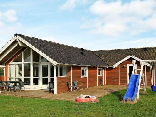 a house with a large deck and a playground at 10 person holiday home in Væggerløse-By Traum in Bøtø By