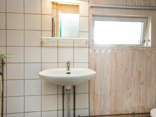 La salle de bains est pourvue d'un lavabo, d'une fenêtre et d'un miroir. dans l'établissement Three-Bedroom Holiday home in Karrebæksminde 1, à Karrebæksminde