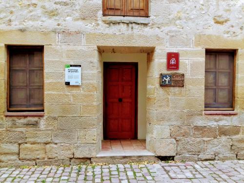 a red door on the side of a stone building at Casa Julián Fábrica Giner in Morella