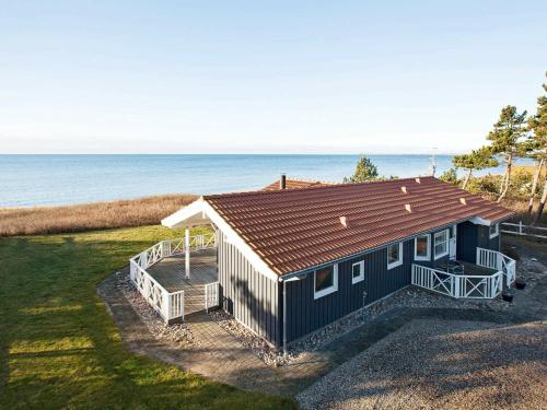 una pequeña casa con techo marrón y el océano en 9 person holiday home in G rlev, en Venemose