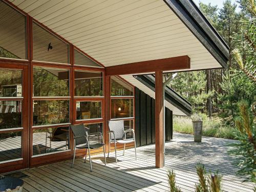 a porch of a house with chairs and windows at 8 person holiday home in Nex in Spidsegård