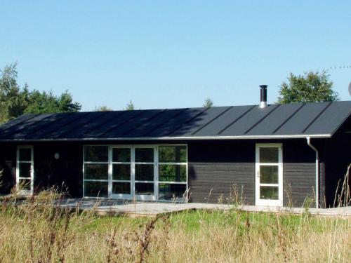 Skattebølleにある6 person holiday home in Tranek rの黒屋根の黒家