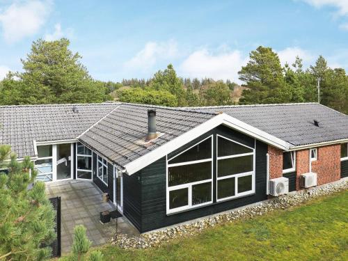 una casa con techo negro y patio en 12 person holiday home in Bl vand, en Ho