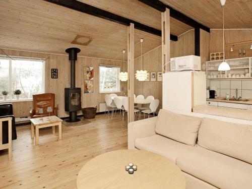 ÅlbækにあるFour-Bedroom Holiday home in Ålbæk 1のリビングルーム(白いソファ付)、キッチンが備わります。