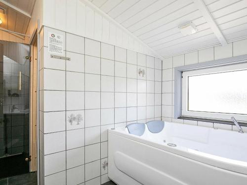 biała łazienka z wanną i oknem w obiekcie 8 person holiday home in Vejers Strand w mieście Vejers Strand