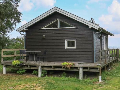 een zwart huis met een veranda en een bank bij 4 person holiday home in Oure in Oure