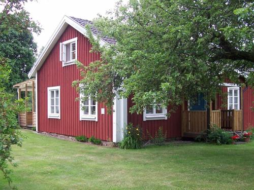 a red house with white windows and a yard at 6 person holiday home in ALSTERBRO in Kättilstorp