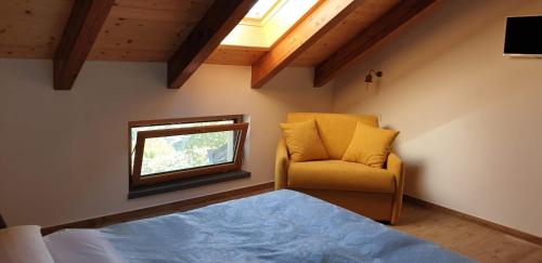 een slaapkamer met een bed, een stoel en een raam bij Agriturismo Mare e Monti in Agerola