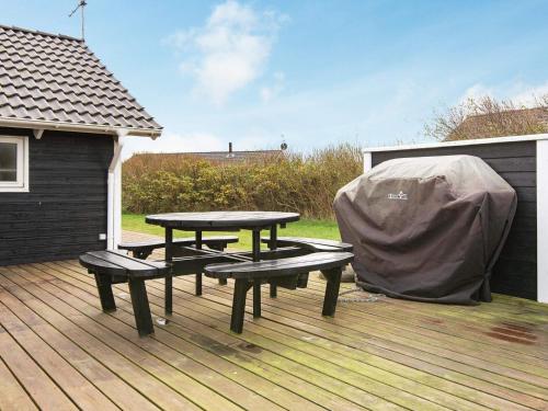 a picnic table and two benches on a deck at 8 person holiday home in Harbo re in Harboør