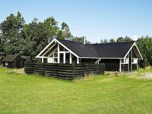 una casa con un techo negro en un campo en 6 person holiday home in Snedsted en Stenbjerg