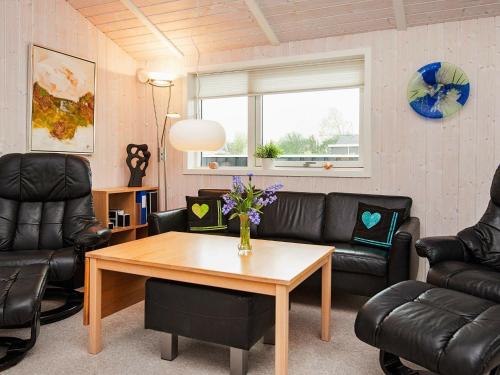 Flovtにある8 person holiday home in Haderslevのリビングルーム(革製家具、テーブル付)