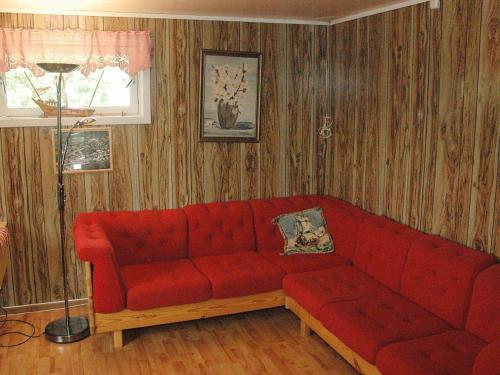 a living room with a red couch and a lamp at Four-Bedroom Holiday home in Åfarnes in Årset