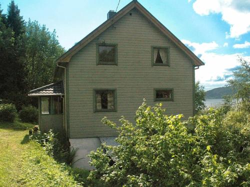 una casa vieja con ventanas en un lado. en Four-Bedroom Holiday home in Åfarnes, en Årset