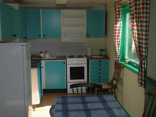 a kitchen with blue cabinets and a white stove top oven at Four-Bedroom Holiday home in Åfarnes in Årset