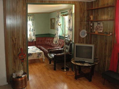 a living room with a red couch and a television at Four-Bedroom Holiday home in Åfarnes in Årset