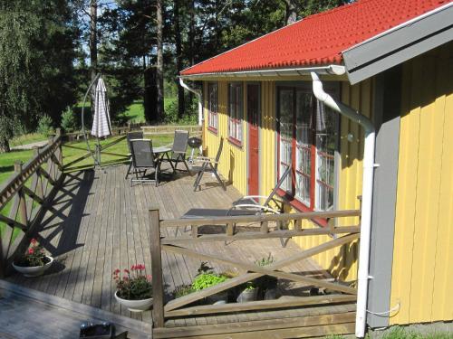a house with a deck with chairs and a table at 4 person holiday home in H CKSVIK in Håcksvik