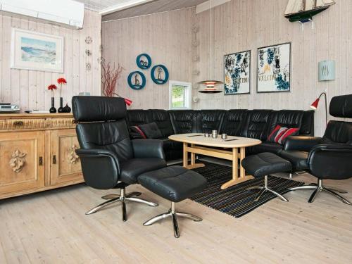 エーベルトフトにある8 person holiday home in Ebeltoftの黒革張りの椅子とテーブルが備わる待合室