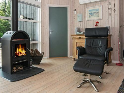 ein Wohnzimmer mit einem Stuhl und einem Kamin in der Unterkunft 8 person holiday home in Ebeltoft in Ebeltoft