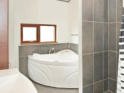 a white bath tub in a bathroom with a window at 8 person holiday home in Ulfborg in Thorsminde