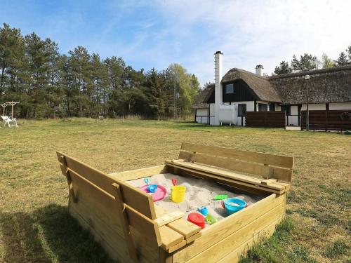 un contenedor de madera lleno de agua en un campo en 6 person holiday home in L s en Læsø