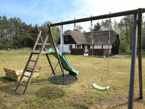un parco giochi vuoto con scala e altalena di 6 person holiday home in L s a Læsø