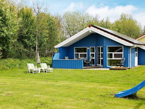 ein blaues Haus mit Spielplatz und Rutsche in der Unterkunft 6 person holiday home in Otterndorf in Otterndorf