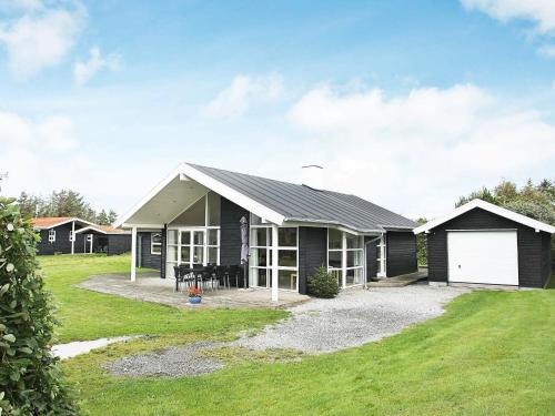 a black house with a white garage at 8 person holiday home in Hjørring-By Traum in Vester Vidstrup