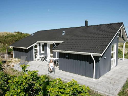 een vrouw op een terras voor een huis bij 5 person holiday home in L kken in Løkken