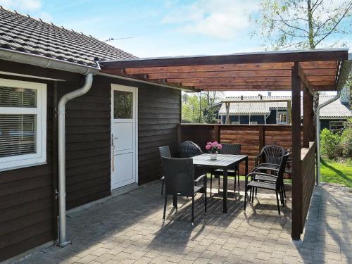 a patio with a table and chairs under a pergola at 6 person holiday home in Hals in Hals