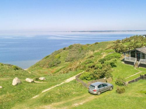 un coche aparcado en una colina cerca del océano en 7 person holiday home in Struer en Remmer Strand