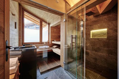 Un baño con ducha de cristal y lavabo. en The Grindelwald Penthouse - GRINDELHOMES, en Grindelwald