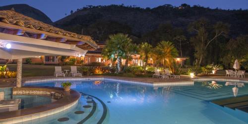 a swimming pool in a resort at night at Quinta da Paz Resort in Itaipava
