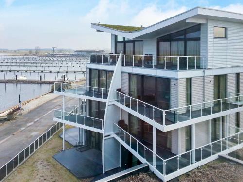 a house with balconies on the side of a body of water at 8 person holiday home in Wendtorf in Wendtorf