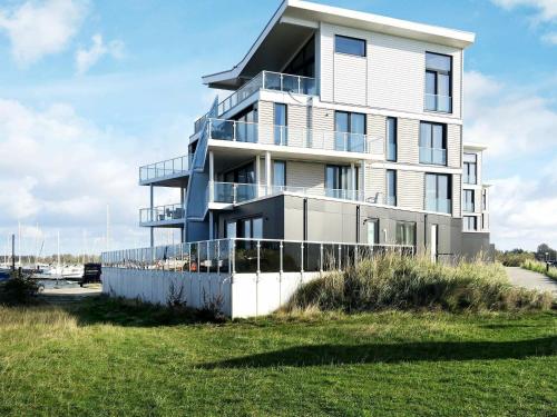 a tall white building with a grassy field in front of it at 4 person holiday home in Wendtorf in Wendtorf