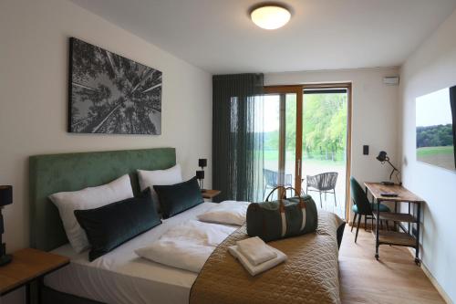 アイヒャッハにあるNaturhotel Wittelsbachのベッドルーム1室(大型ベッド1台、デスク付)