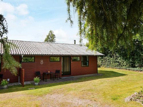 a small red house with a table in front of it at 5 person holiday home in Silkeborg in Silkeborg