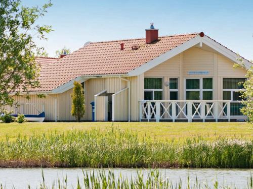ein Haus mit einem weißen Haus mit einem roten Dach in der Unterkunft 6 person holiday home in Otterndorf in Otterndorf