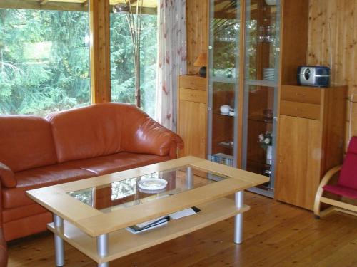 a living room with a leather couch and a coffee table at 4 person holiday home in Skibby in Skibby
