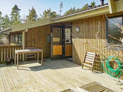 dom z drewnianym tarasem ze stołem i ławką w obiekcie 6 person holiday home in Nex w mieście Vester Sømarken
