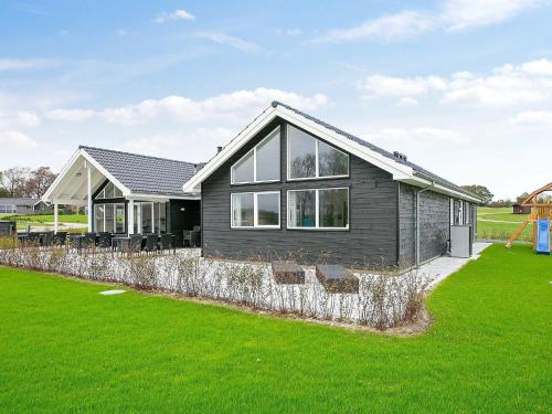ファーボにある18 person holiday home in Faaborgの芝生の黒い家