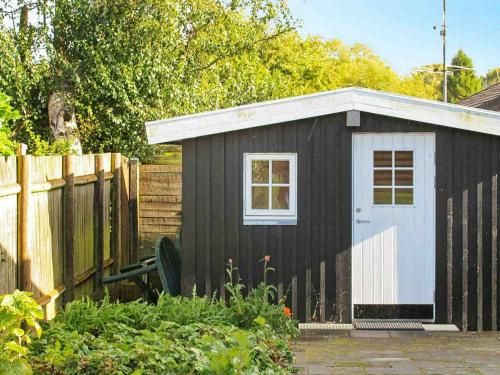 a black and white shed with a white door at 6 person holiday home in Str by in Strøby