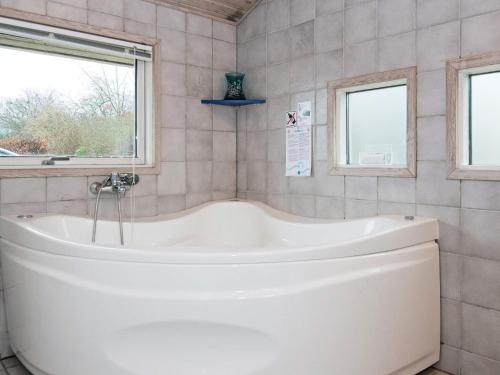 baño con bañera blanca y ventana en Two-Bedroom Holiday home in Bjert 1 en Sønder Bjert