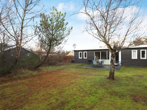 un patio con una casa y un árbol en 6 person holiday home in Thisted, en Klitmøller