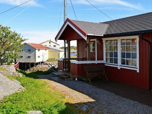 a red house with a bench on a porch at 3 person holiday home in Henningsv r in Henningsvær