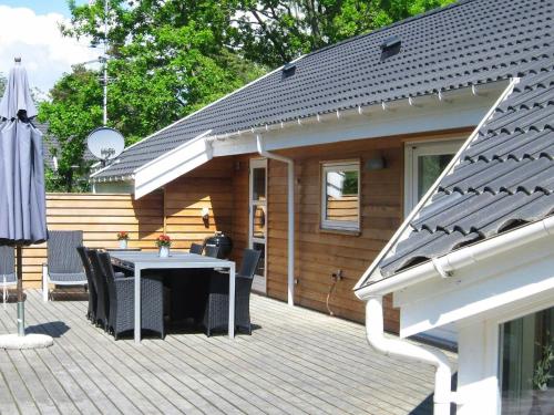 Vester Sømarkenにある10 person holiday home in Aakirkebyのパティオ(テーブル、デッキチェア付)