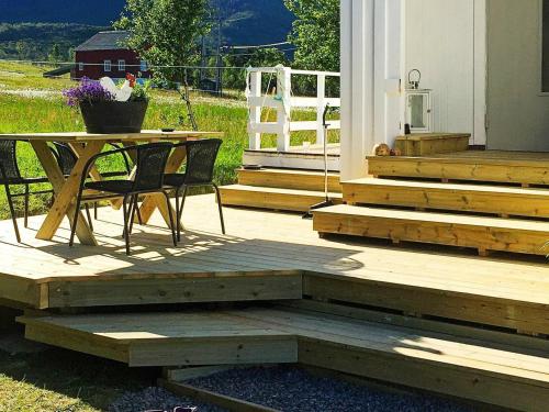 una terraza de madera con mesa, mesa y sillas en 6 person holiday home in Senjahopen, en Mefjordvær