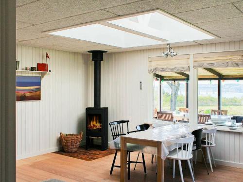 une salle à manger avec une table et une cheminée dans l'établissement Holiday home Roslev III, à Roslev